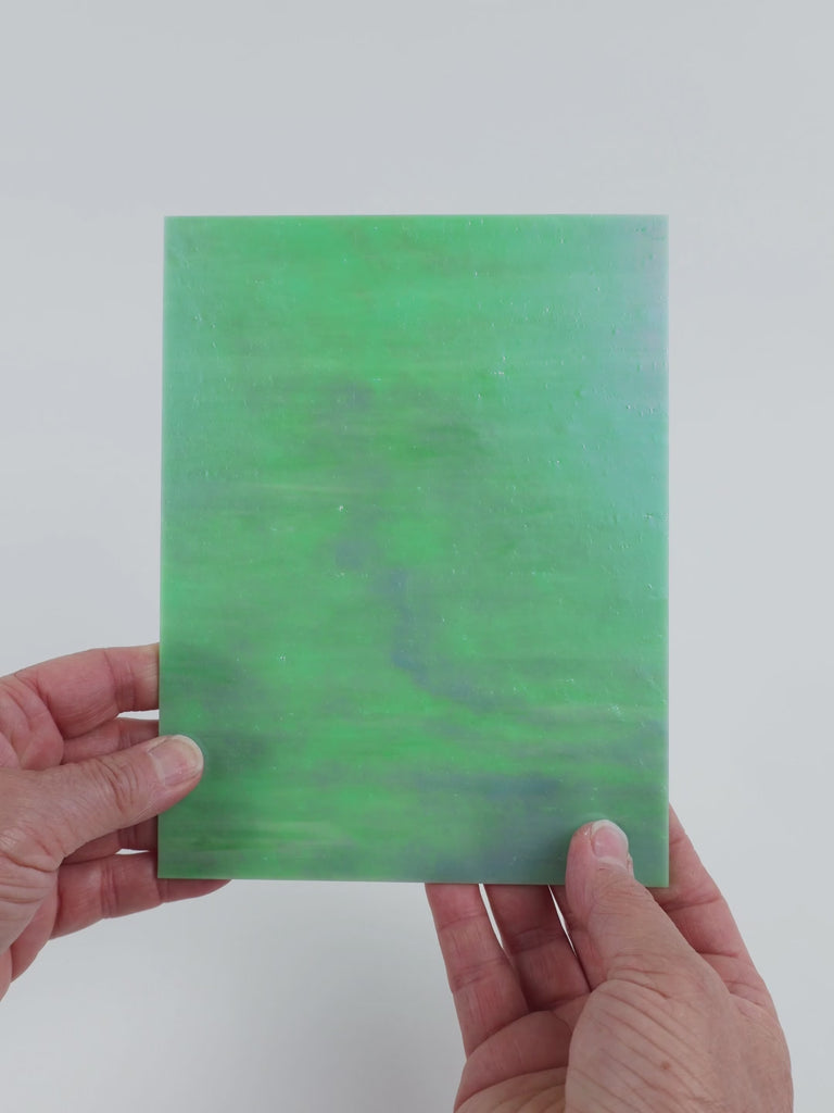 Video of the Pistachio Ice glass plate in iridised translucent teal, 15x19cm, held up and tilted to show its pattern and transparency
