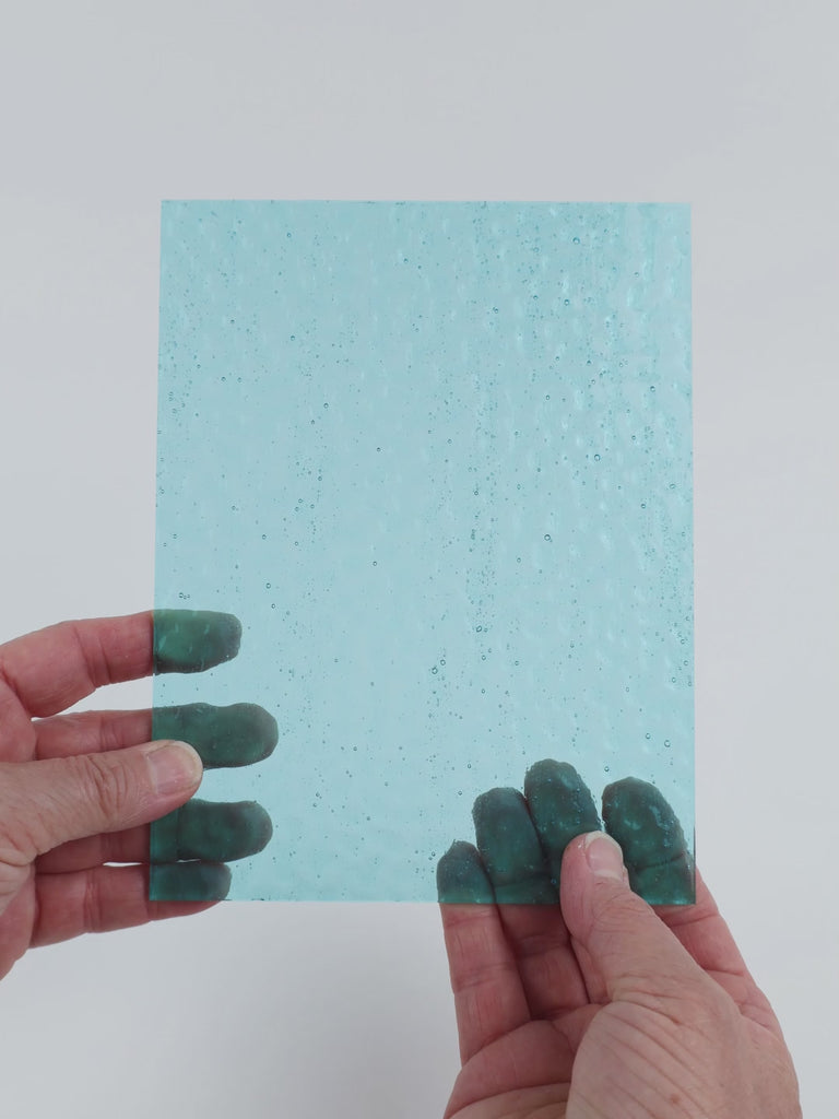 Video of the Aqua Gentle Waves glass plate in hammered transparent blue, 15x19cm, held up and tilted to show its pattern and transparency
