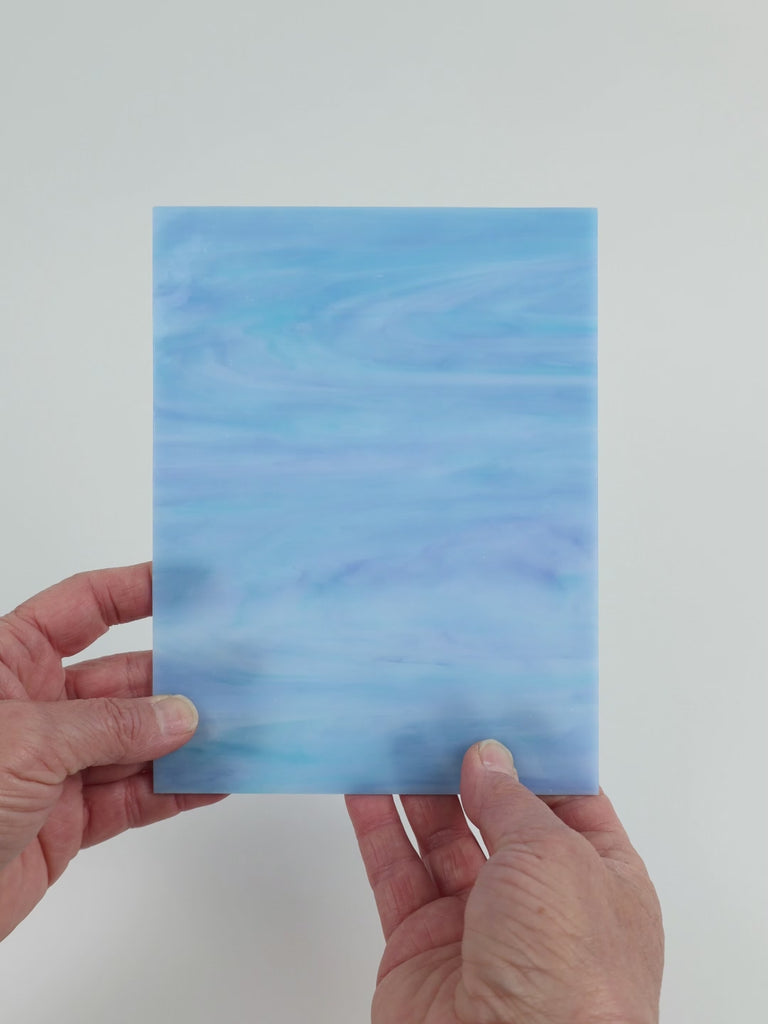 Video of the Soft Blue Opal glass plate in translucent blue, 15x19cm, held up and tilted to show its pattern and transparency