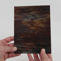 Video of the Charred Bark glass plate in opaque brown, 15x19cm, held up and tilted to show its pattern and transparency