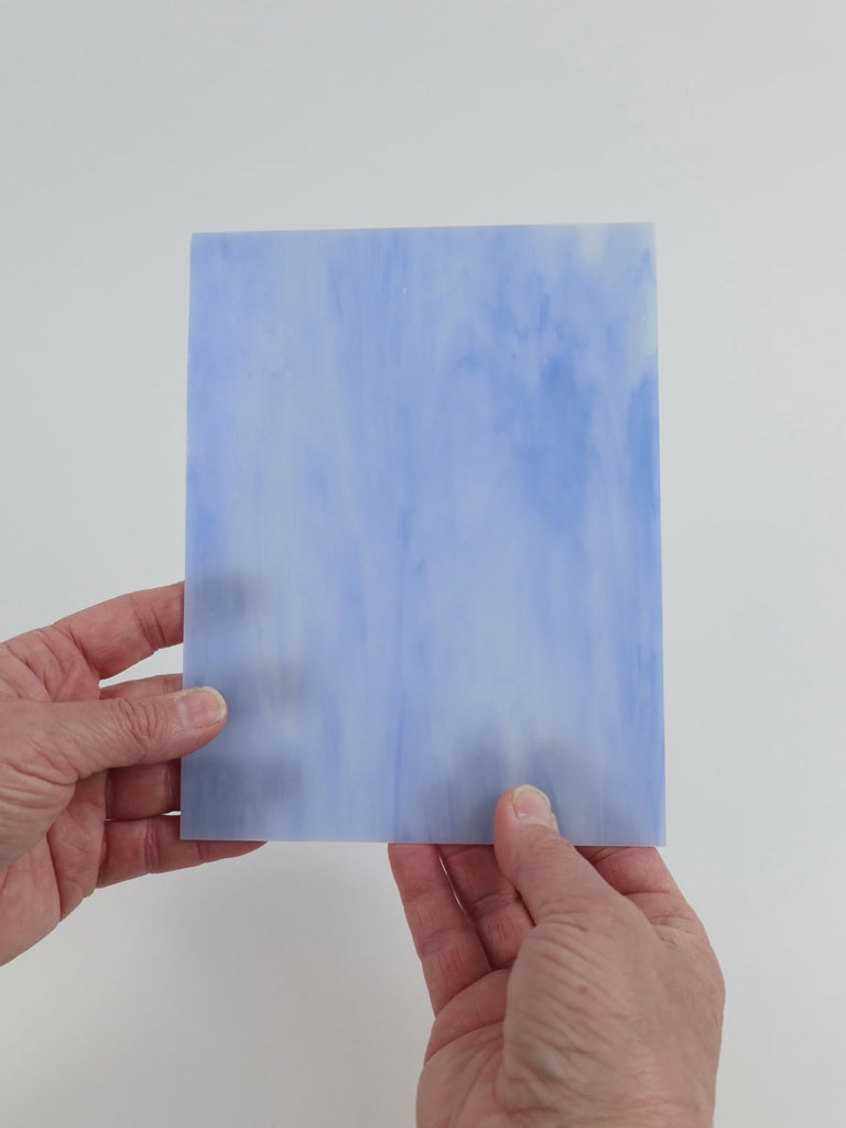 Video of the Soft Cloud glass plate in translucent blue , 15x19cm, held up and tilted to show its pattern and transparency