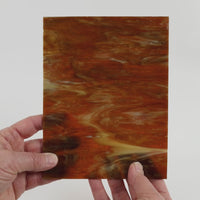 Video of the Syrup glass plate in translucent brown, 15x19cm, held up and tilted to show its pattern and transparency