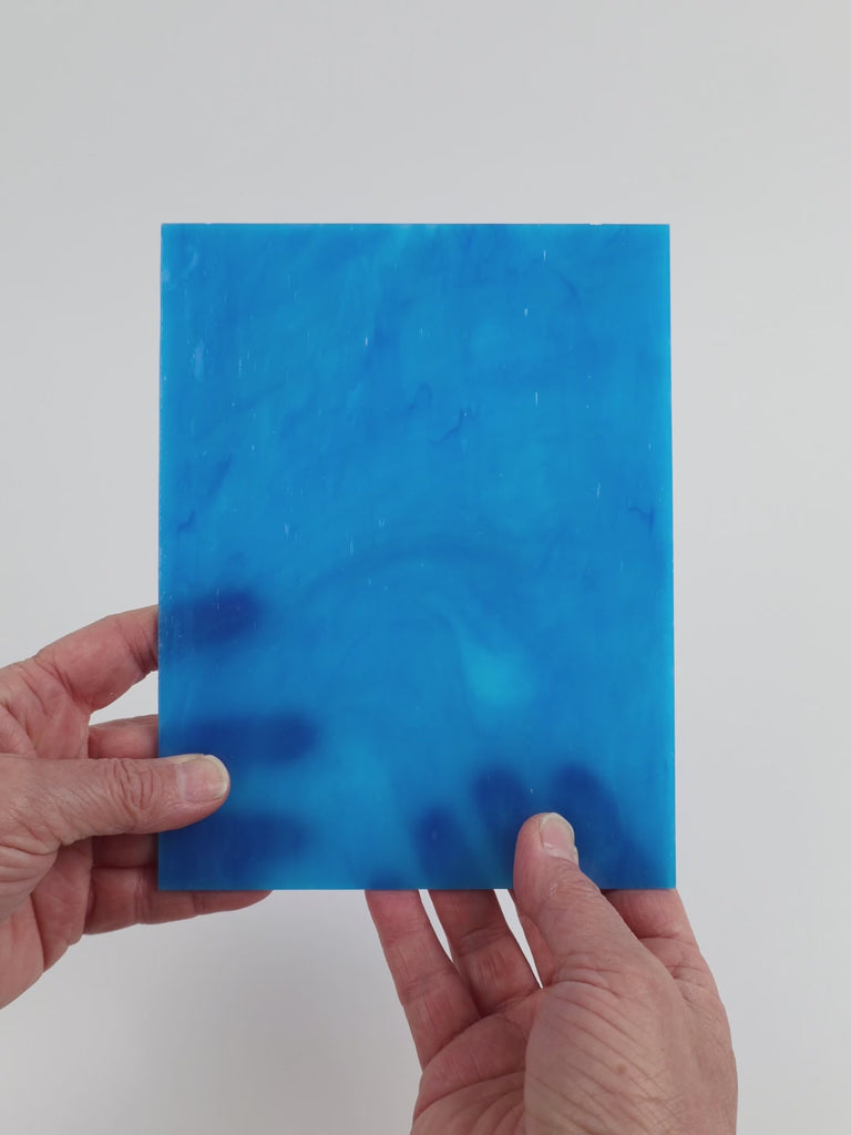 Video of the Deep Turquoise Streaky glass plate in translucent turquoise, 15x19cm, held up and tilted to show its pattern and transparency