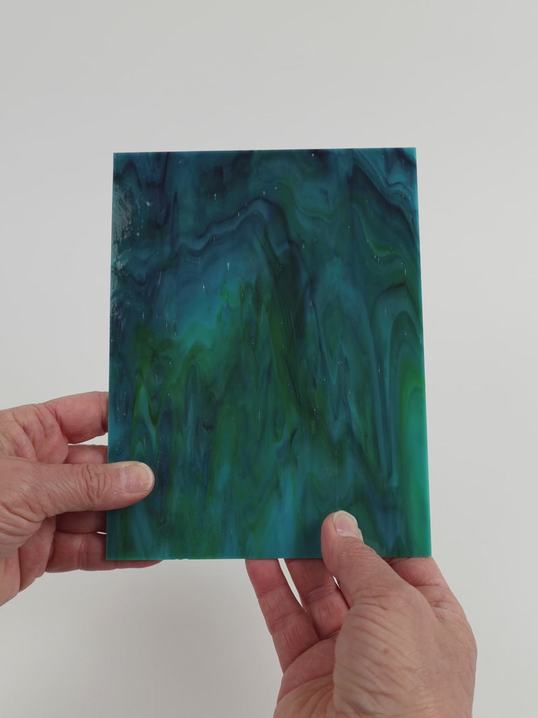 Video of the Waverider glass plate in translucent teal, 15x19cm, held up and tilted to show its pattern and transparency