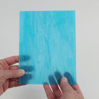 Video of the Egyptian Scarab glass plate in translucent turquoise, 15x19cm, held up and tilted to show its pattern and transparency